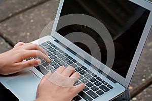 Young student using laptop outdoors