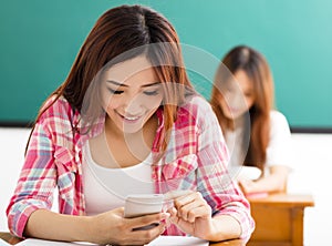 Young student using smart phone in classroom