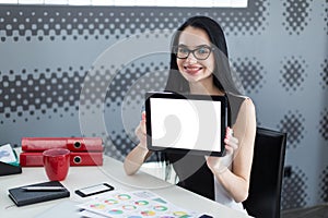 Young student woman in office holding a tablet and smiling