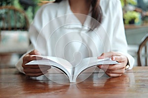 Young student woman sitting at library and reading book prepare