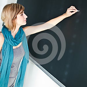 Young student writing on the blackboard