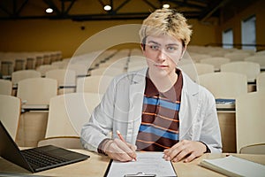 Young Student Writing Notes During Lecture
