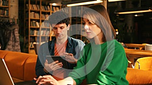 Young students collaborating on project in university library colleagues working in modern coworking