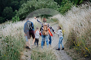 Young students having fun during biology field teaching class, running down the dirt path. Dedicated teachers during