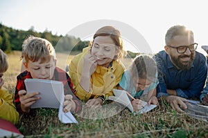 Young students learning about nature, forest ecosystem during biology field teaching class, writing notes. Teachers