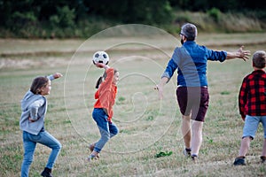 Young students playing with teacher outdoors, in nature, during field teaching class, having fun. Dedicated teachers