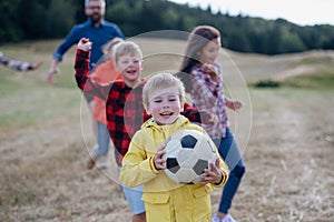 Young students playing with teacher outdoors, in nature, during field teaching class, having fun. Dedicated teachers