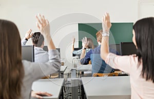 Young students raising hands in a classroom