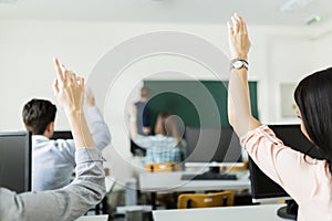 Young students raising hands in a classroom