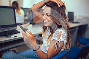 Young students using phone in a computer lab