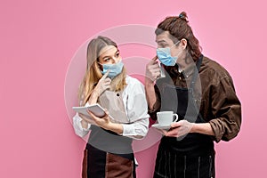 young students work as waiters, stand having conversation during work
