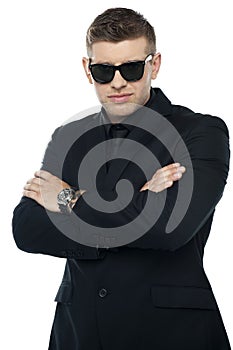 Young stylish bouncer in a black suit, arms folded