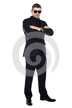 Young stylish bouncer in a black suit, arms folded photo