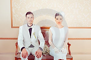 Young stylish bride and groom on sofa