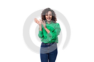 young stylish caucasian brunette woman with curled hair dressed in a green shirt posing on a white background with copy