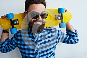 Young stylish confident happy handsome man with skateboard