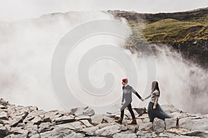 Young stylish couple in love in wool sweaters together near Dettifoss waterfall