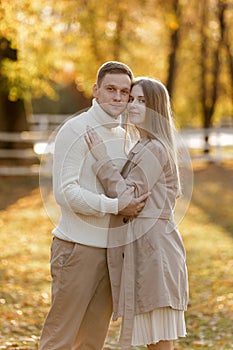 Young stylish couple lovers are hugging in the autumn park. Lovely romantic moment between man and woman in love. Happy