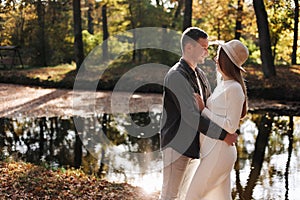 Young stylish couple lovers are hugging in the autumn park. Lovely romantic moment between man and woman in love. Happy