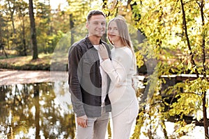 Young stylish couple lovers are hugging in the autumn park. Lovely romantic moment between man and woman in love. Happy