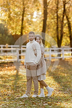 Young stylish couple lovers are hugging in the autumn park. Lovely romantic moment between man and woman in love. Happy