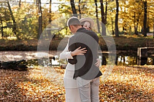 Young stylish couple lovers are hugging in the autumn park. Lovely romantic moment between man and woman in love. Happy