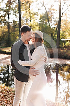 Young stylish couple lovers are hugging in the autumn park. Lovely romantic moment between man and woman in love. Happy