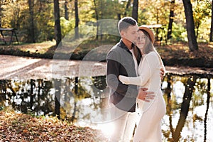 Young stylish couple lovers are hugging in the autumn park. Lovely romantic moment between man and woman in love. Happy