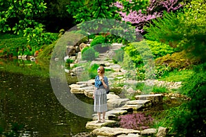 Young stylish girl have a rest near a pond