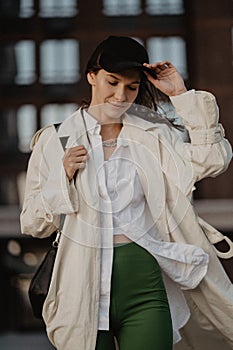 young stylish girl on the street. Fashionable beautiful woman walking around the city.