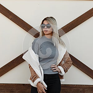 Young stylish girl in vintage gray sweater with fashion jacket
