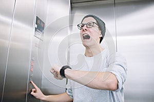 Young stylish guy standing in elevator