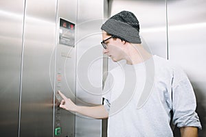 Young stylish guy standing in elevator