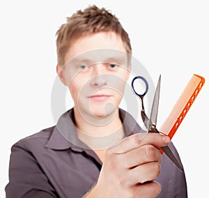 Young stylish haircutter holding scissors and brush.