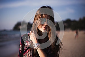 Young stylish happy hipster woman traveling around the world wearing aviator sunglasses, denim shirt, tropical island