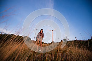 Young stylish hipster girl enjoy sunset on viewpoint. Travel woman with backpack