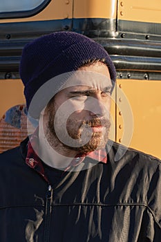 Young stylish hipster man looking across the street as he exits a bus