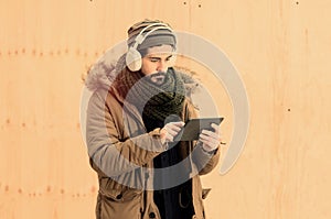 Young stylish hipster man using tablet with a warm tone filter a