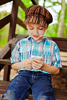 Giovane elegante un bambino giochi sul telefono 