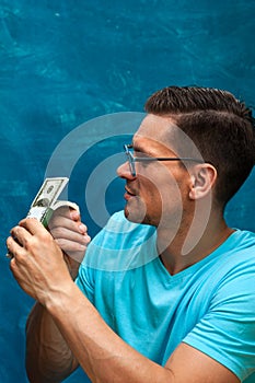 Young stylish man counting heaps of money