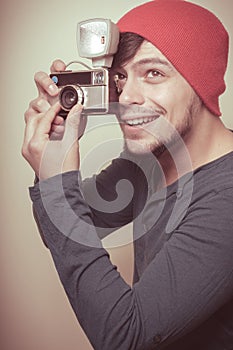 Young stylish man holding old camera