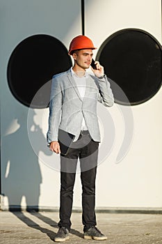 A young stylish man in a protective helmet against the backdrop of a seaport