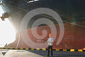 A young stylish man in a protective helmet against the backdrop of a seaport