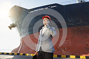 A young stylish man in a protective helmet against the backdrop of a seaport