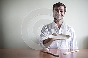 Young stylish man with white shirt eating in mealtimes
