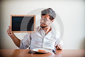 Young stylish man with white shirt holding blackboard