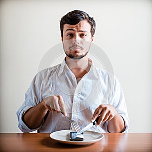 Young stylish man with white shirt and phone on the dish
