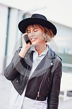 Young stylish urban woman calling indoors, calmness photo