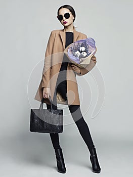 Young stylish woman in beige coat