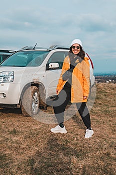 young stylish woman portrait in front of off road suv car